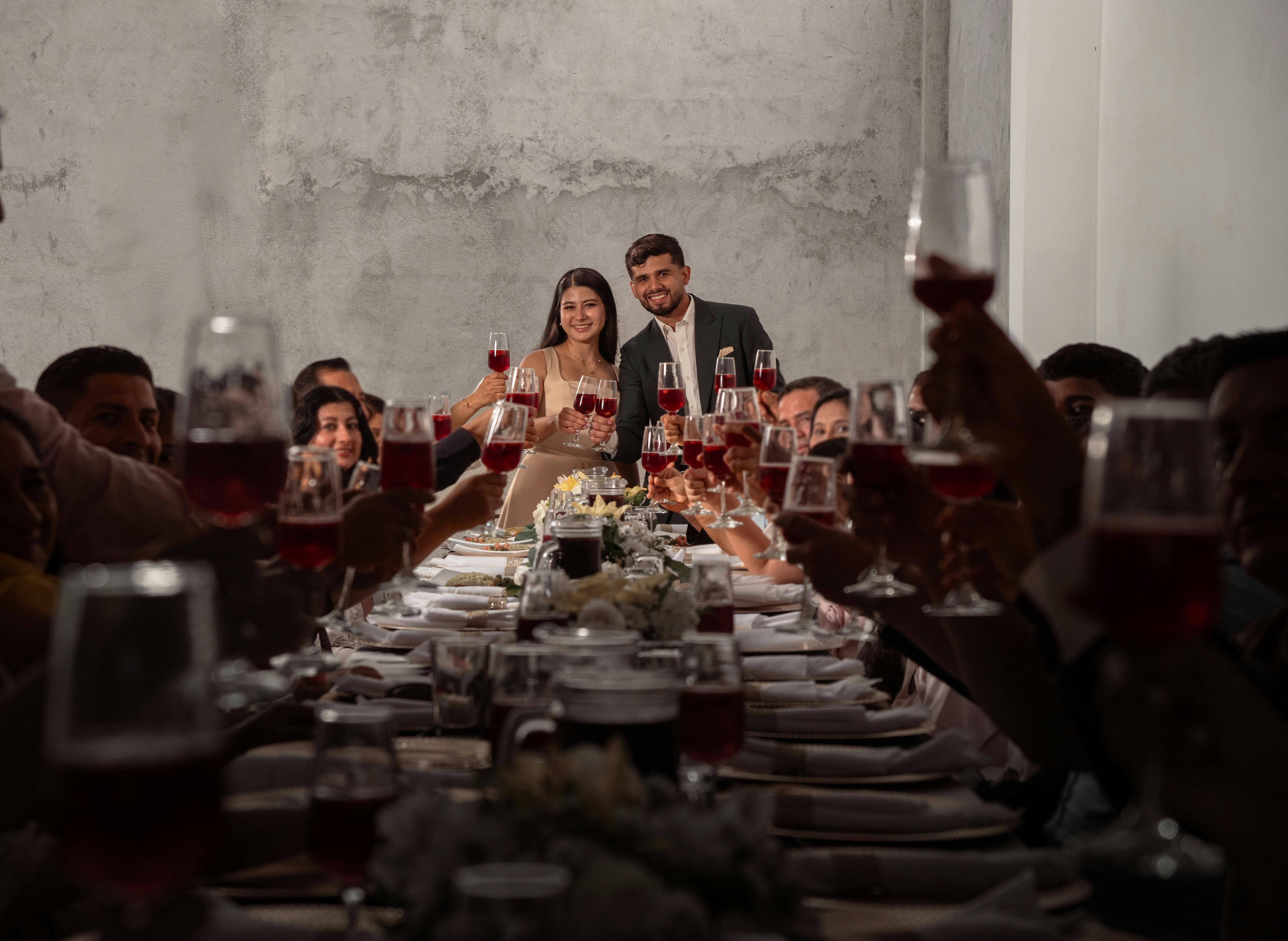Wedding toast with guests raising red wine glasses